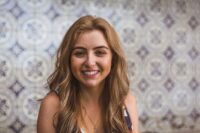 A young blonde woman against a tiled background