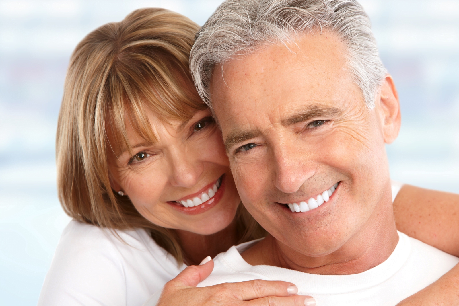 Man and Woman in white t-shirts smiling at the camera